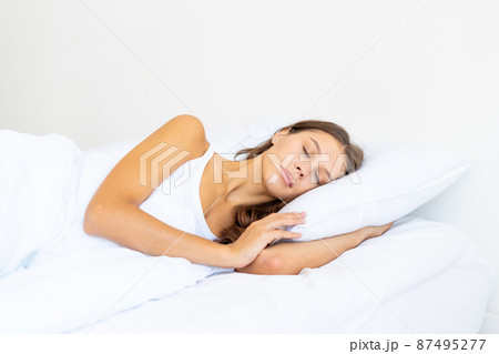 Side view waist portrait of beautiful sleeping woman in bed. Female with long hair resting Side view waist portrait of beautiful sleeping woman in bed. Female with long hair resting 87495277