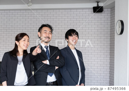 見上げる3人のサラリーマン　指差し 87495366