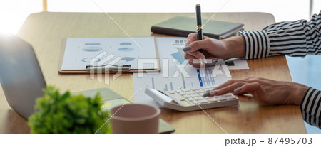 Close up Business woman using calculator for do math finance on wooden desk in office and business working background, tax, accounting, statistics and analytic research concept 87495703