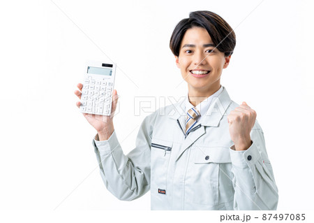 白バックで電卓を持つ若い男性の作業員 白バックで電卓を持つ若い男性の作業員 87497085