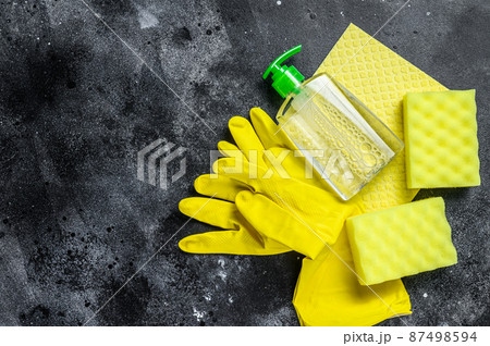 Kitchen yellow cleaning concept, housecleaning, hygiene, spring, chores, cleaning supplies. Black background. Top view. Copy space Kitchen yellow cleaning concept, housecleaning, hygiene, spring, chores, cleaning supplies. Black background. Top view. Copy space 87498594