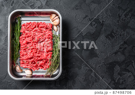 Raw beef Forcemeat, ground meat. Black background. Top view. Copy space Raw beef Forcemeat, ground meat. Black background. Top view. Copy space 87498706