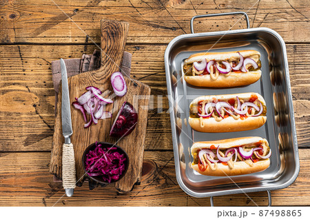 Vegan Vegetarian hot-dogs with onion and meatless sausage. Wooden background. Top view Vegan Vegetarian hot-dogs with onion and meatless sausage. Wooden background. Top view 87498865