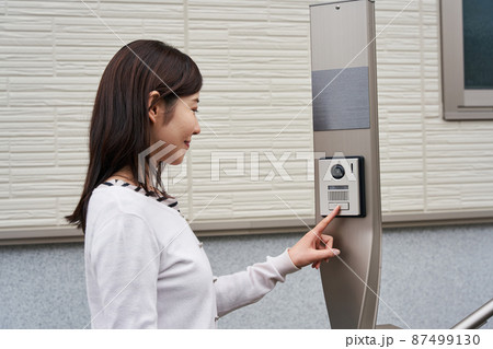 インターフォンを押す女性 87499130