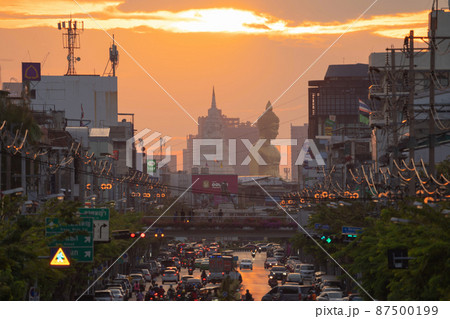 Aerial view of the Giant Golden Buddha in Wat Paknam Phasi Charoen Temple with cars on traffic street road in Phasi Charoen district, Bangkok. Urban town, Thailand. Downtown City. 87500199