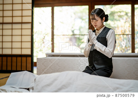 仏衣を着せる葬儀スタッフ（納棺師） 87500579