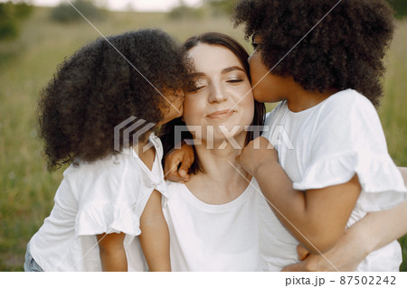 Caucasian mother is kissed by her mixed race daughters Caucasian mother is kissed by her mixed race daughters 87502242