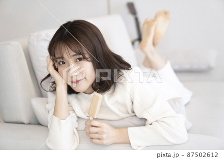 ソファーでアイスを食べる女性 ソファーでアイスを食べる女性 87502612