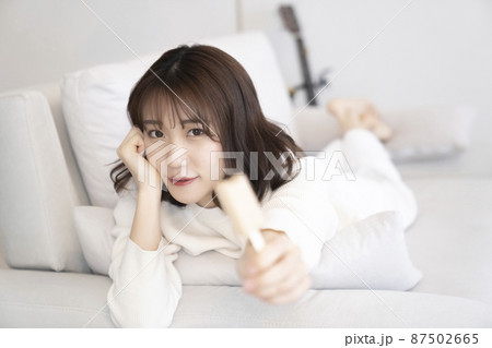 ソファーでアイスを食べる女性 87502665