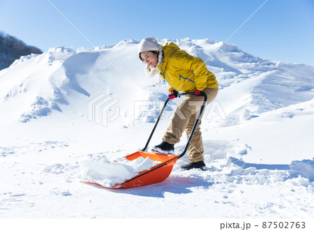 雪かきをする女性 87502763