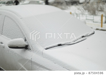 Car is in snow. Icy vehicles. In winter in parking lot. This car is after precipitation. Car is in snow. Icy vehicles. In winter in parking lot. This car is after precipitation. 87504596
