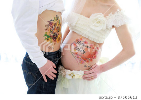 マタニティーフォト、妊婦さんと旦那さんのお腹アップ 87505613