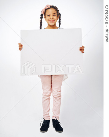 This one is for all the kids. Studio shot of an adorable little girl holding a blank placard. 87506275