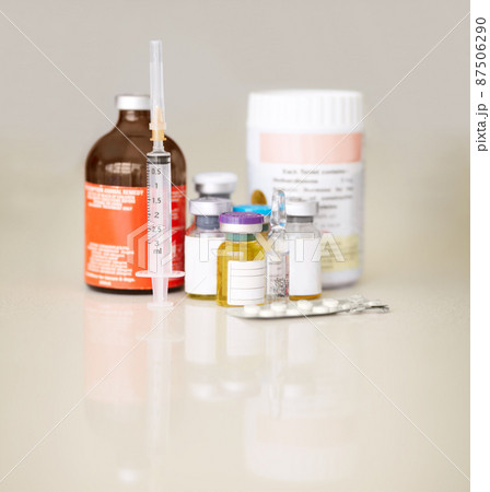 A mass of medicine. Bottles of medicine and pills with a syringe and needle. A mass of medicine. Bottles of medicine and pills with a syringe and needle. 87506290
