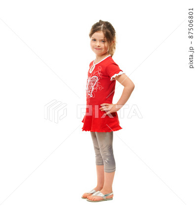 Cute and sassy. Cute little girl standing against a white background. 87506801