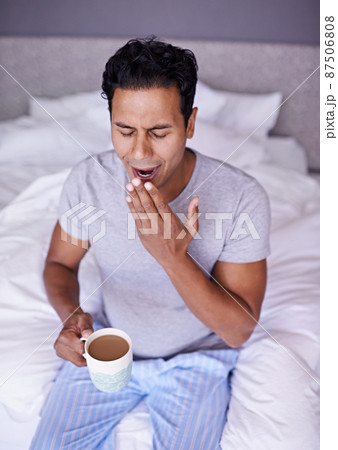 I wish I could straight back to bed. A handsome male holding a hot beverage. I wish I could straight back to bed. A handsome male holding a hot beverage. 87506808