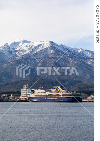 【新潟県】客船を迎える早春の両津港と大佐渡山脈 87507075