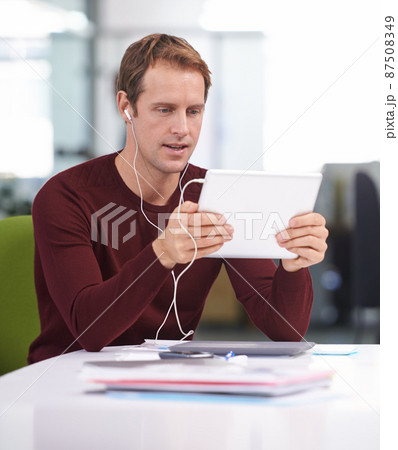 Finding the perfect song. A handsome businessman working at his desk. Finding the perfect song. A handsome businessman working at his desk. 87508349