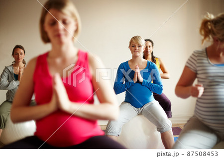 Blissful maternity. A multi-ethnic group of pregnant women meditating on exercise balls in a yoga class. Blissful maternity. A multi-ethnic group of pregnant women meditating on exercise balls in a yoga class. 87508453