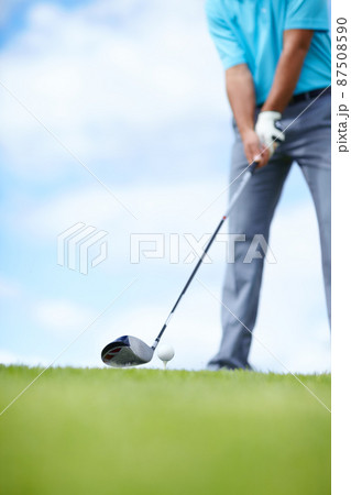 Grounding the club. Cropped image of a young male golfer teeing up to play a shot with his driver. 87508590
