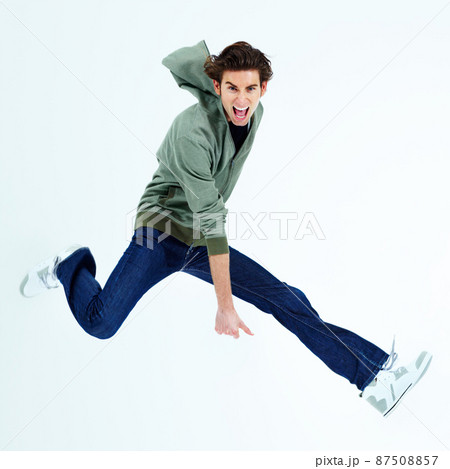 Yeah - Enjoying freedom. Portrait of a young man jumping out and shouting loudly. 87508857
