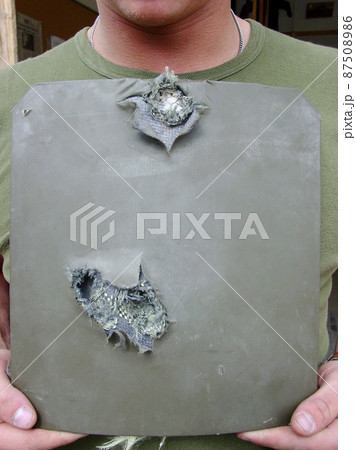 Shot of a soldier holding up pierced body armor- this is the real thing from KFOR, Kosovo 1999. This image is part of our historic collection. The digital cameras available back then where very bad 87508986