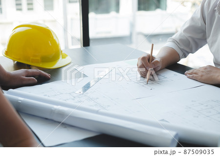 Team of engineers and architects, working team, meeting, discussing construction and drawing construction plans, printing, writing on-site construction sites. Home design concept Team of engineers and architects, working team, meeting, discussing construction and drawing construction plans, printing, writing on-site construction sites. Home design concept 87509035