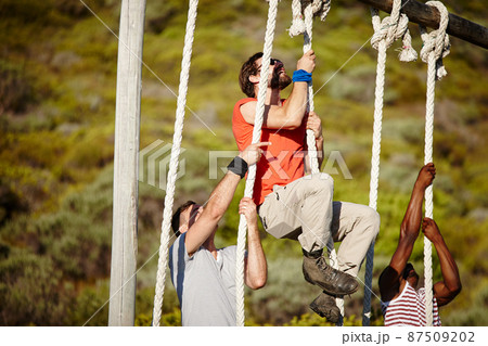 Boot camp is rough, so you gotta be tough. Shot of a group of men climbing up ropes at a military bootcamp. Boot camp is rough, so you gotta be tough. Shot of a group of men climbing up ropes at a military bootcamp. 87509202