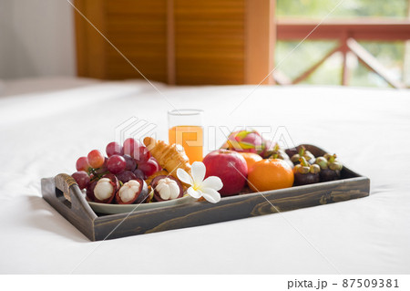 Focus on fruit. In a hotel room with fruit, place a tray on the bed to welcome the arrival of VIP guests Focus on fruit. In a hotel room with fruit, place a tray on the bed to welcome the arrival of VIP guests 87509381