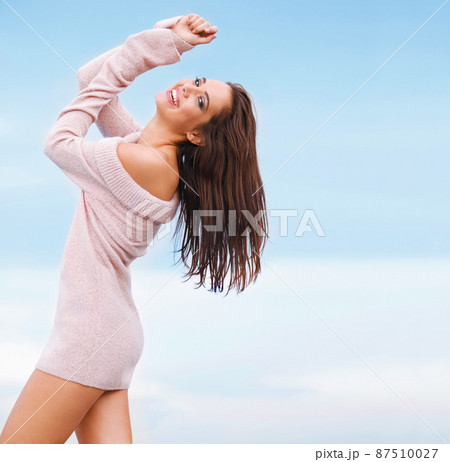 Feeling confident and free. Happy woman in pink sweater having fun outdoors on sky background. 87510027