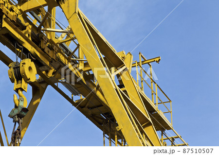 Metal construction of the crane, against the sky, in the warehouse Metal construction of the crane, against the sky, in the warehouse 87510507