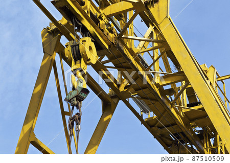 Metal construction of the crane, against the sky, in the warehouse Metal construction of the crane, against the sky, in the warehouse 87510509