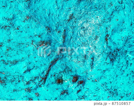 bulk paint on a piece of metal. the texture is turquoise, interspersed with rust and holes. peeling paint, cracked material on background 87510857