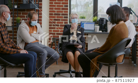 Woman therapist talking to people with addiction at aa group meeting during pandemic Woman therapist talking to people with addiction at aa group meeting during pandemic 87511927