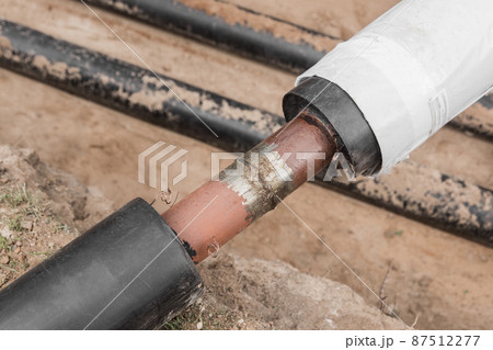 Repair of the water line of the heating main pipe in the ground trench pipeline at the construction site work industry Repair of the water line of the heating main pipe in the ground trench pipeline at the construction site work industry 87512277