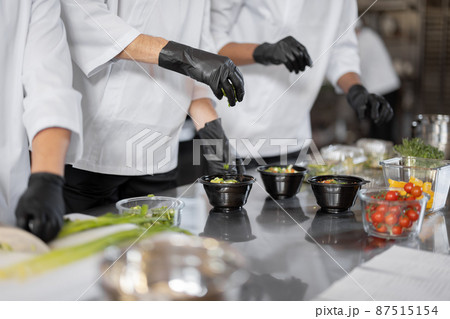 Chefs prepare takeaway food in professional kitchen Chefs prepare takeaway food in professional kitchen 87515154