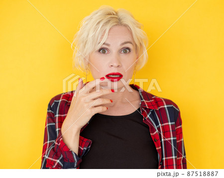 Shocked news. Disbelief woman. Unbelievable story. Surprised middle-aged lady looking confused hands up isolated yellow. 87518887