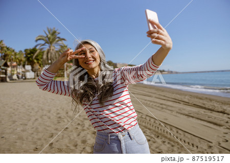 Happy urban woman relaxing outdoors by sea 87519517