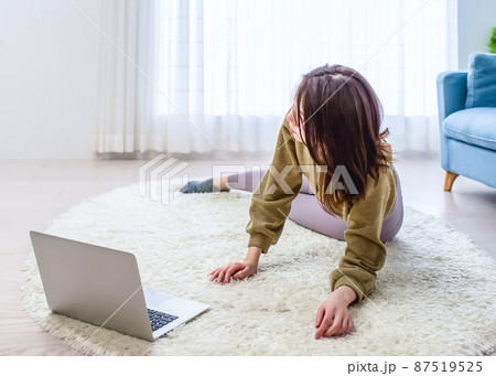 自宅でヨガレッスンを受講する若い女性 自宅でヨガレッスンを受講する若い女性 87519525
