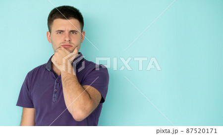 Problem considering. Thoughtful man. Find solution. Puzzled handsome guy in casual t-shirt holding hand on chin isolated blue copy space. Problem considering. Thoughtful man. Find solution. Puzzled handsome guy in casual t-shirt holding hand on chin isolated blue copy space. 87520171