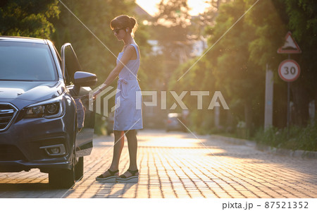 Young woman driver getting inside her car. Transportation and traffic concept. Young woman driver getting inside her car. Transportation and traffic concept. 87521352