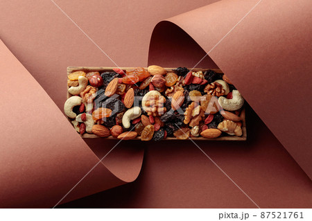 The mix of dried fruits and berries on a brown background. The mix of dried fruits and berries on a brown background. 87521761
