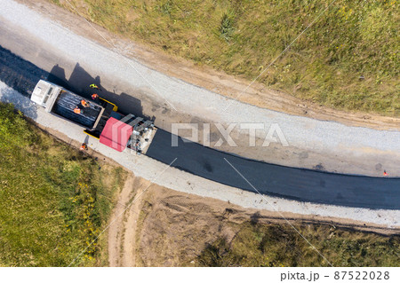 Aerial view of new road construction with asphalt laying machinery at work. 87522028