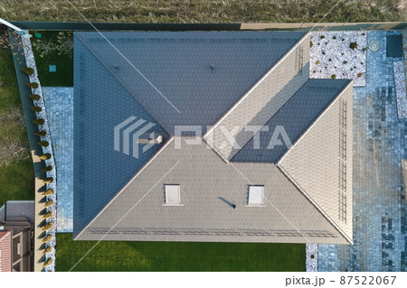 Aerial view of house roof top covered with ceramic shingles. Tiled covering of building under construction Aerial view of house roof top covered with ceramic shingles. Tiled covering of building under construction 87522067