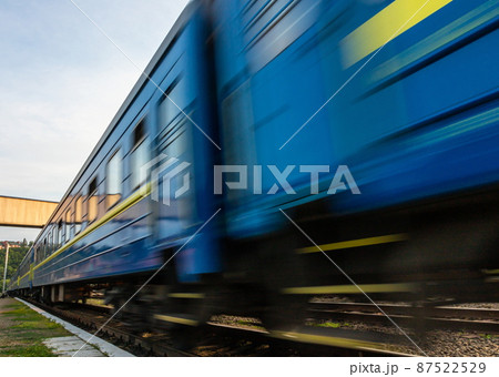 a blue passenger train travels along the track 87522529