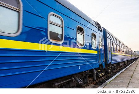 a blue passenger train travels along the track 87522530