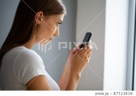 The young woman does not look away from the phone The young woman does not look away from the phone 87523616