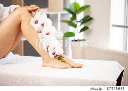 Slim long woman legs with pink flowers. Slim long woman legs with pink flowers. 87523683