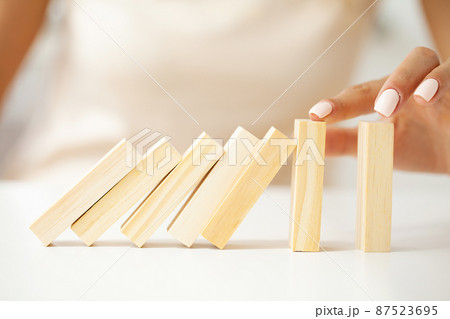 Hand of woman stopping and protect wooden block falling 87523695