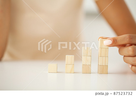 Hand arranging wood block stacking as step stair. 87523732